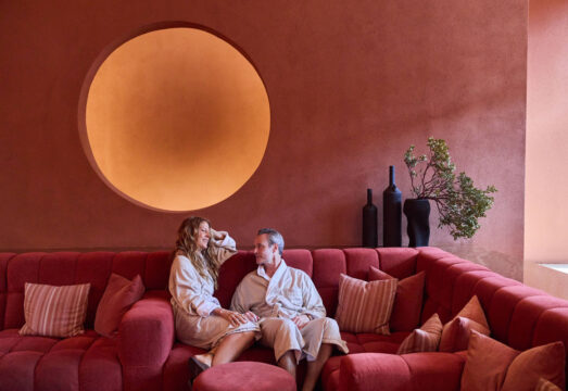 couple sitting in living room on red couch