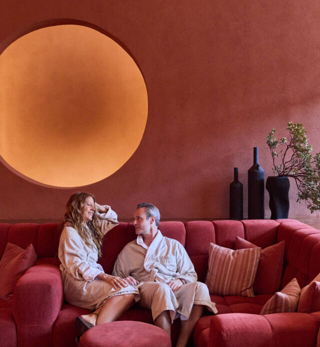 couple on red couch in Mii amo Living Room