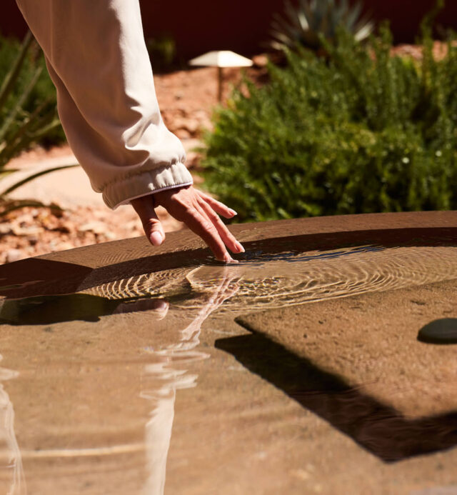 water fountain with hand reaching to touch the water