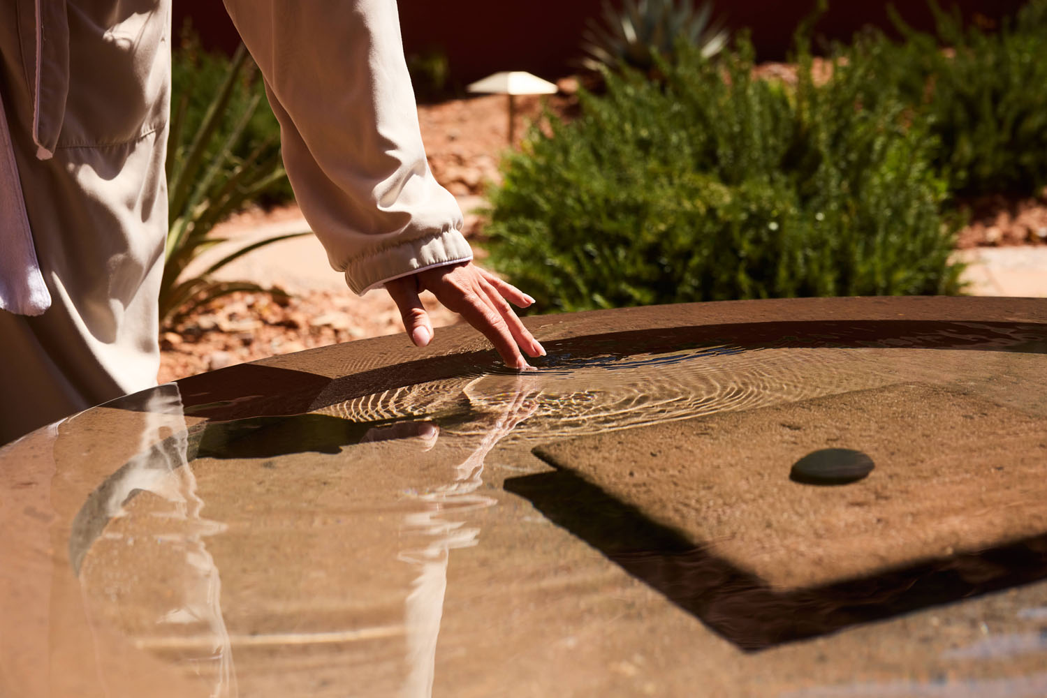 water fountain with hand reaching to touch the water